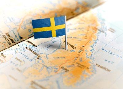 A Sweden flag pin is placed on a map, indicating the country's location and significance in a geographical context.